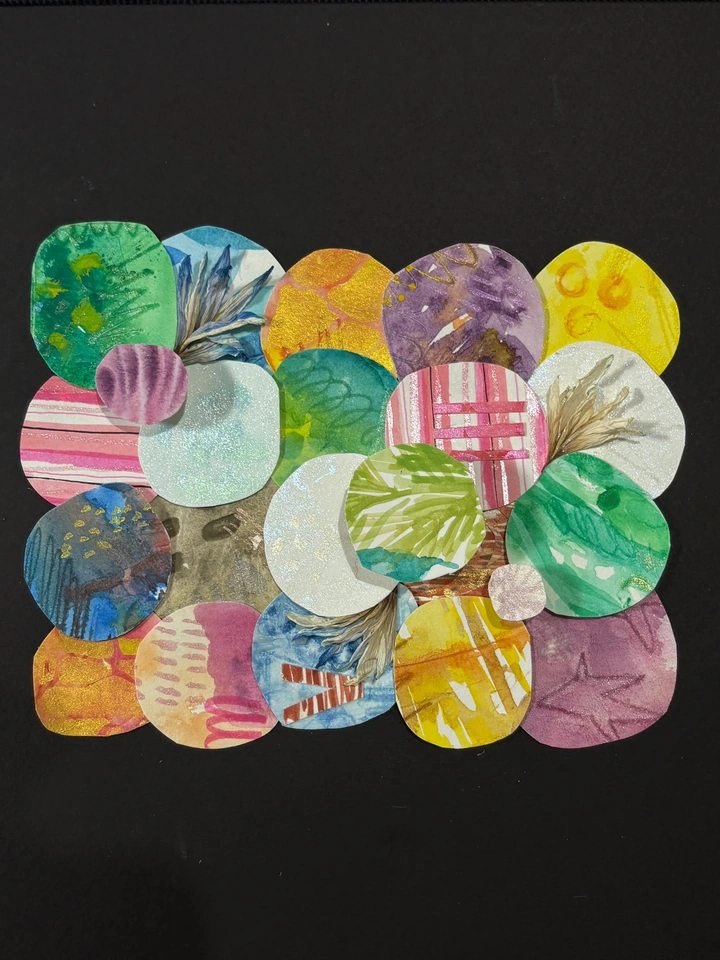 Overlapping watercolor circles and dried petals in green, blue, pink, violet and gold on a dark background.
